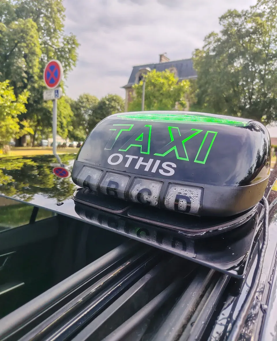 Lumineux de toit TAXI OTHIS et numéro de licence 4860 sur le pavillon du véhicule